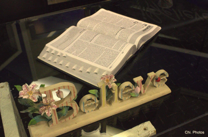 Display of an open Bible and scroll work 'Believe' on glass table at Dr. Gwen Ford's 'I Believe' TV studio.